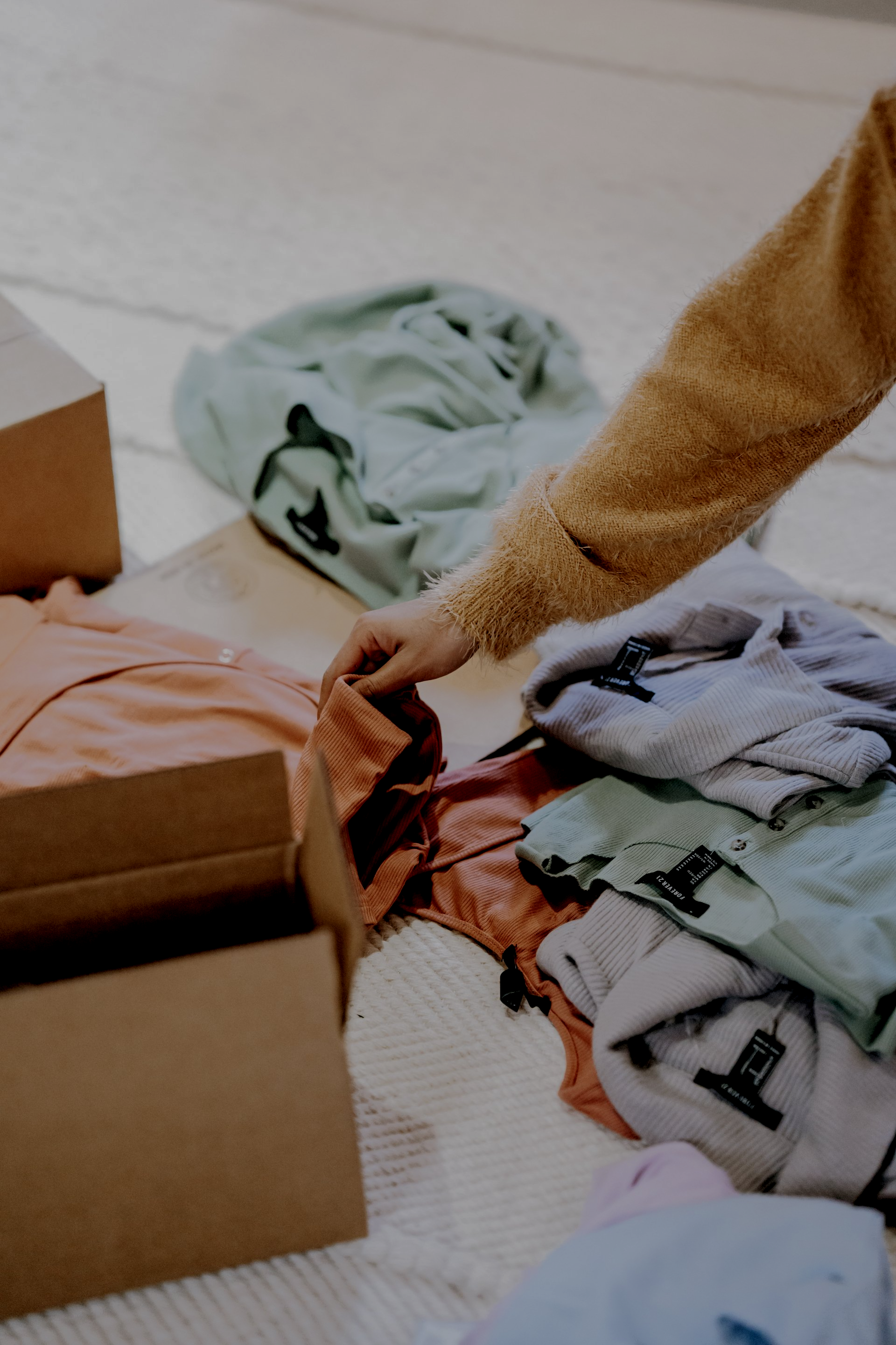 一个人正在把衣服放进纸箱里。