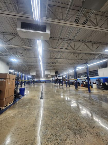 A large warehouse with a lot of lights and boxes on the floor.
