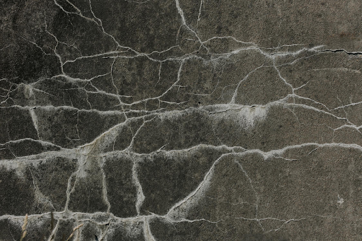 A close up of a cracked concrete surface.