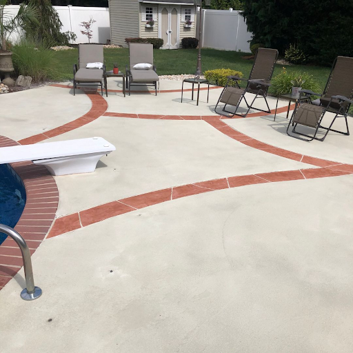 A patio with chairs and a swimming pool in the background