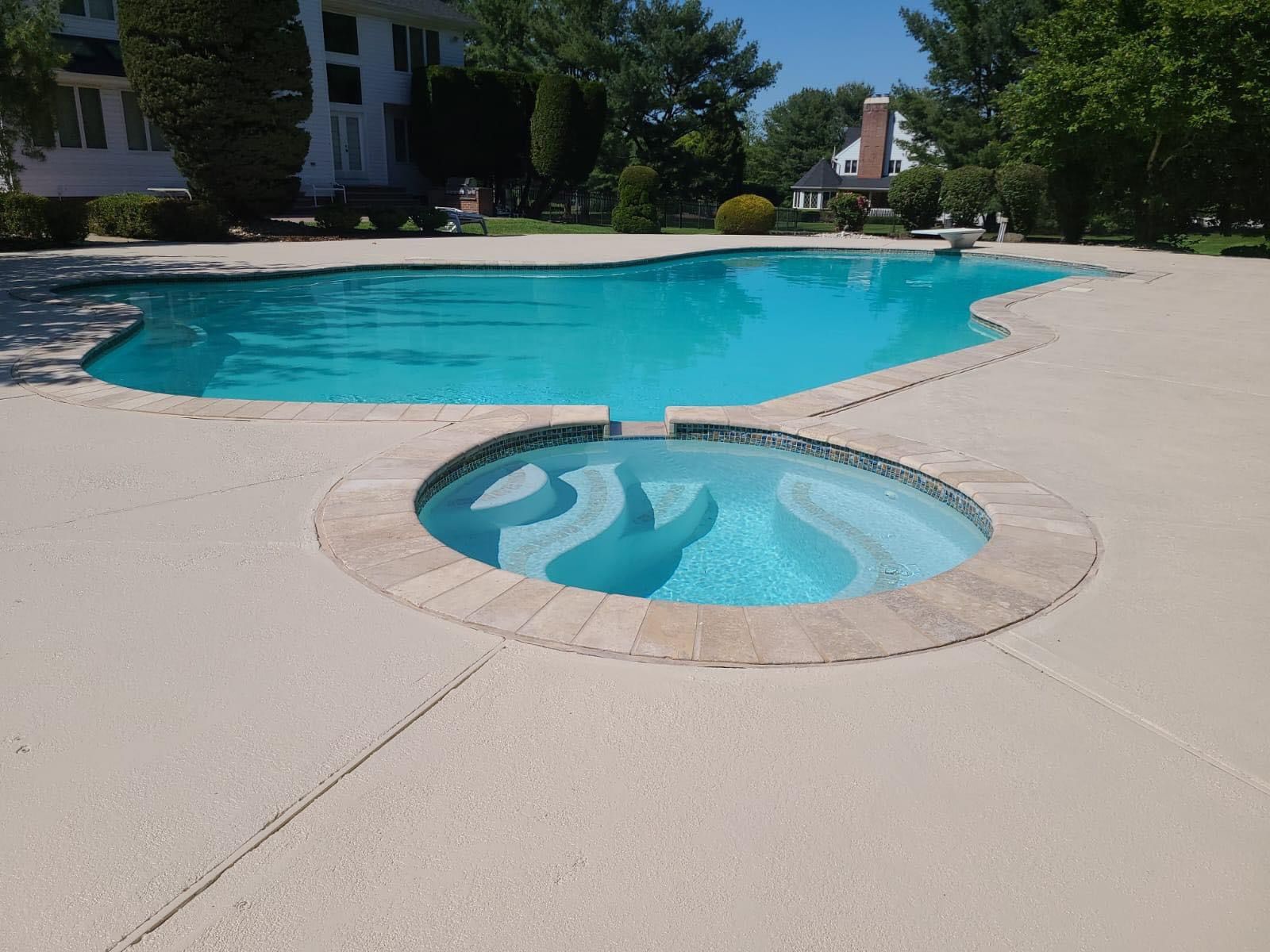 A large swimming pool with a hot tub in the middle