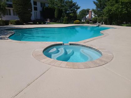 A large swimming pool with a hot tub in the middle