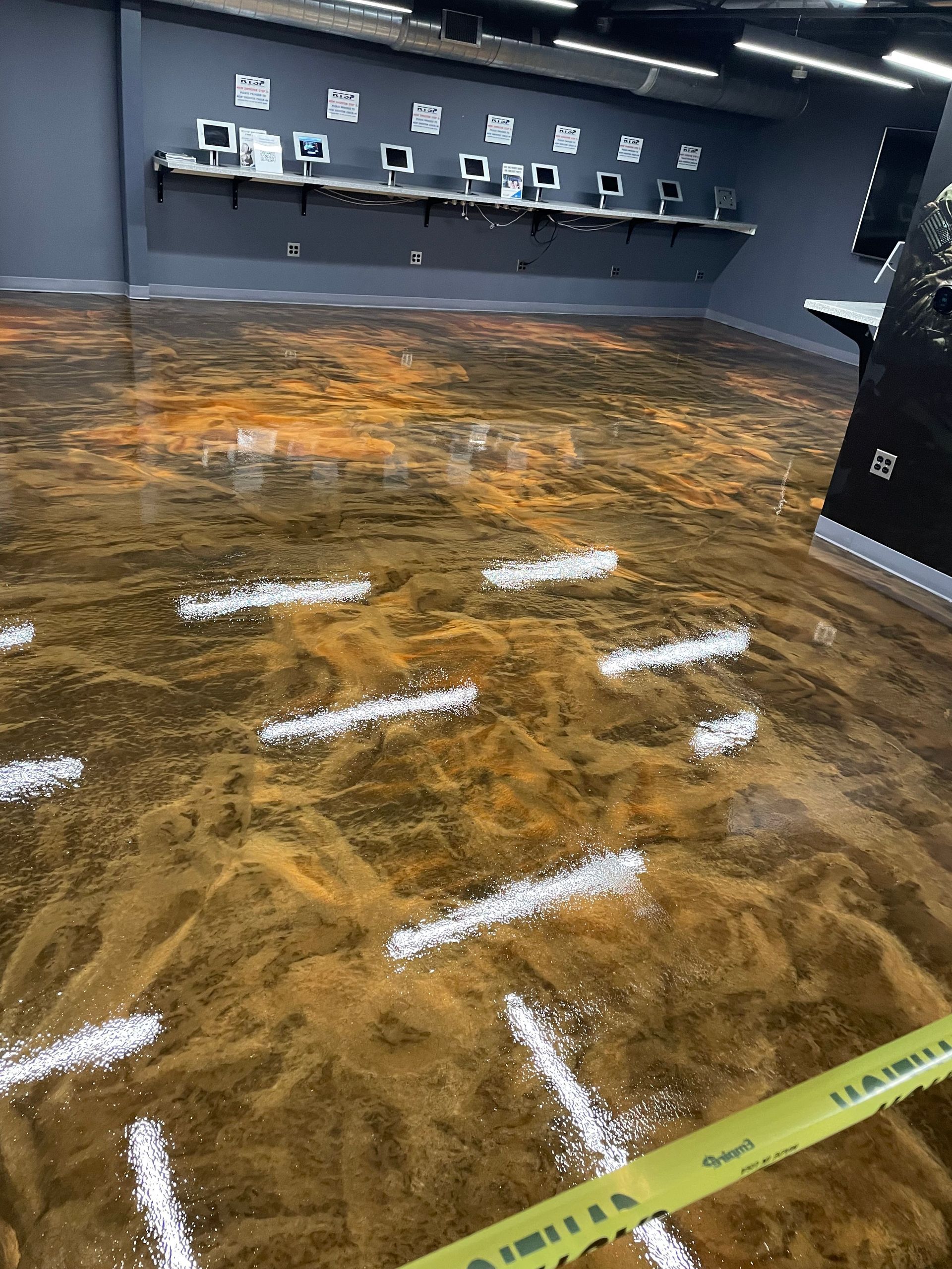 A room with a shiny floor and a yellow tape on the floor.