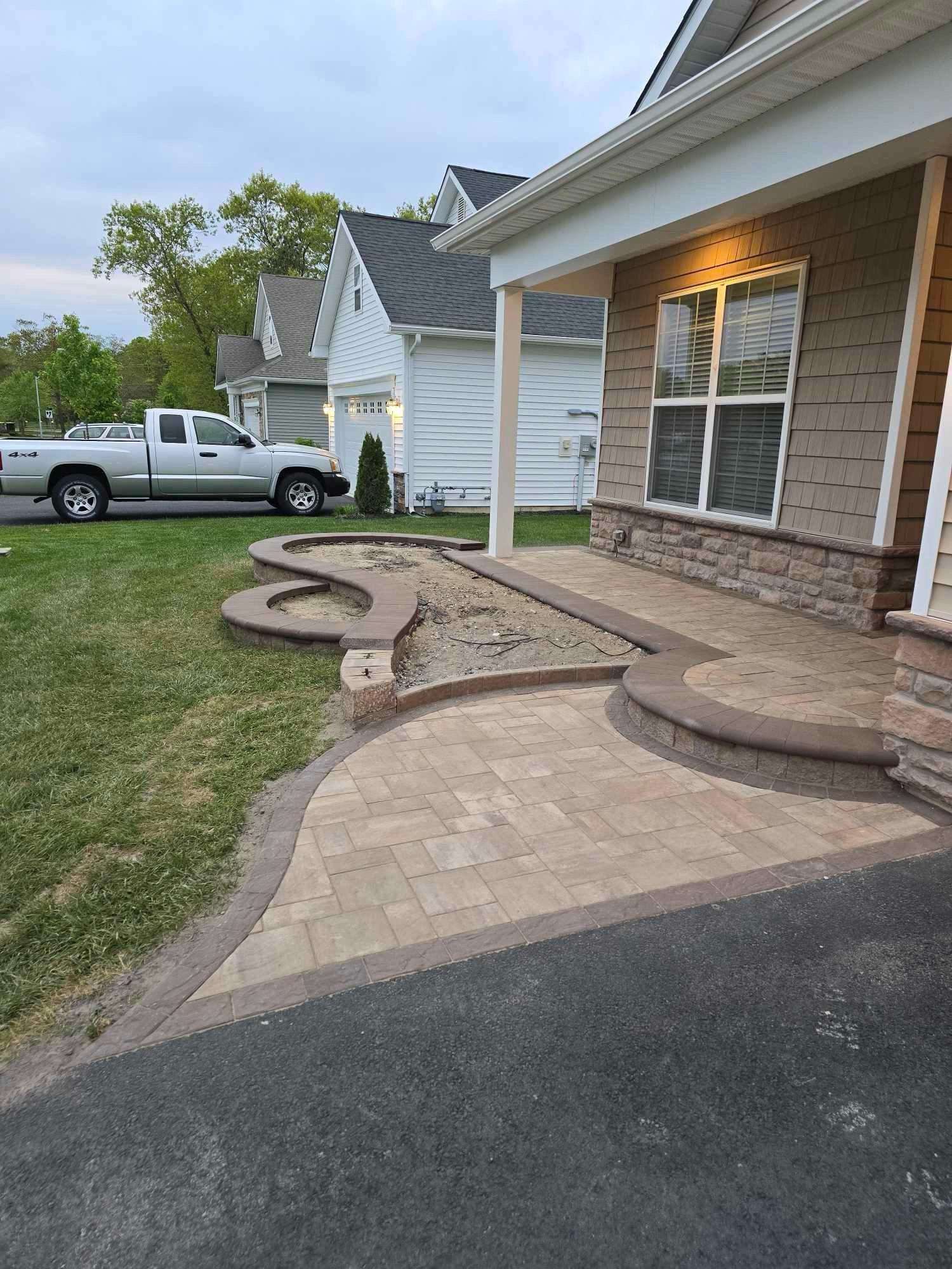 A truck is parked in front of a house with a walkway.