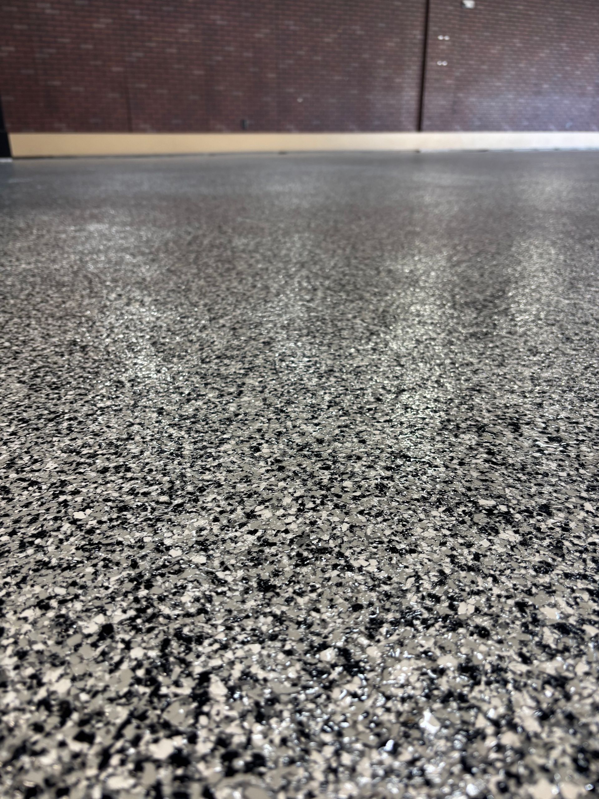 A close up of a gray and black floor with a lot of small stones on it.