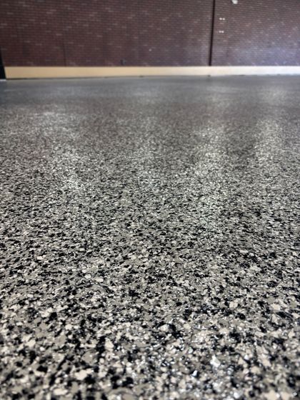 A close up of a gray and black floor with a lot of small stones on it.