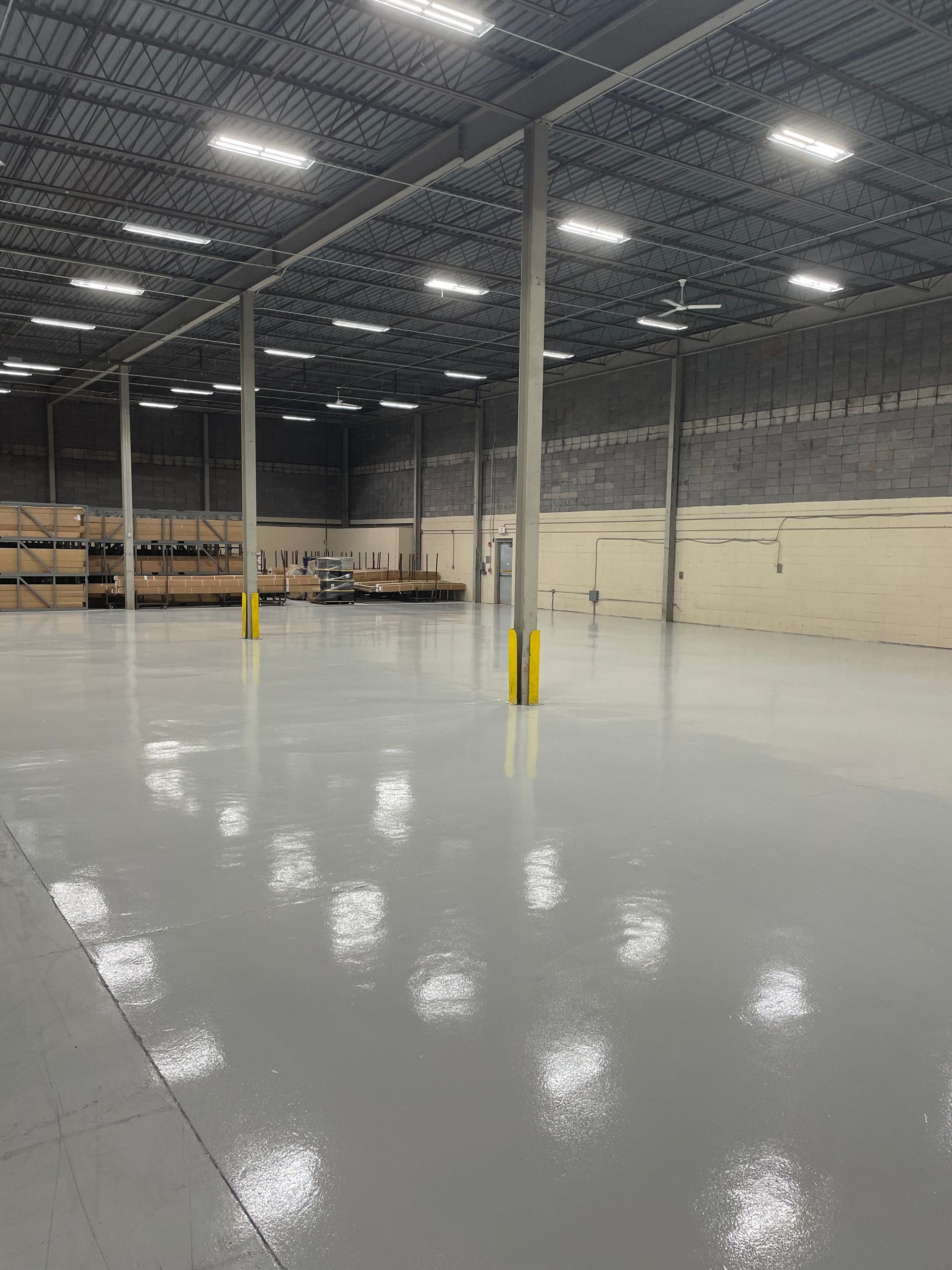 A large warehouse with a shiny floor and lots of lights.