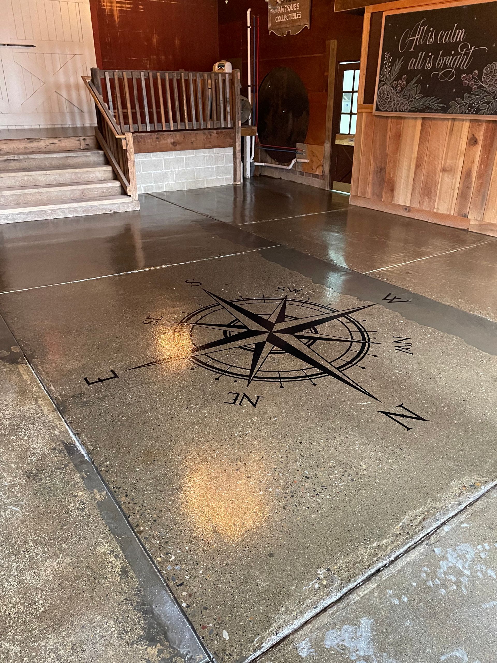 A compass is painted on the floor of a building.