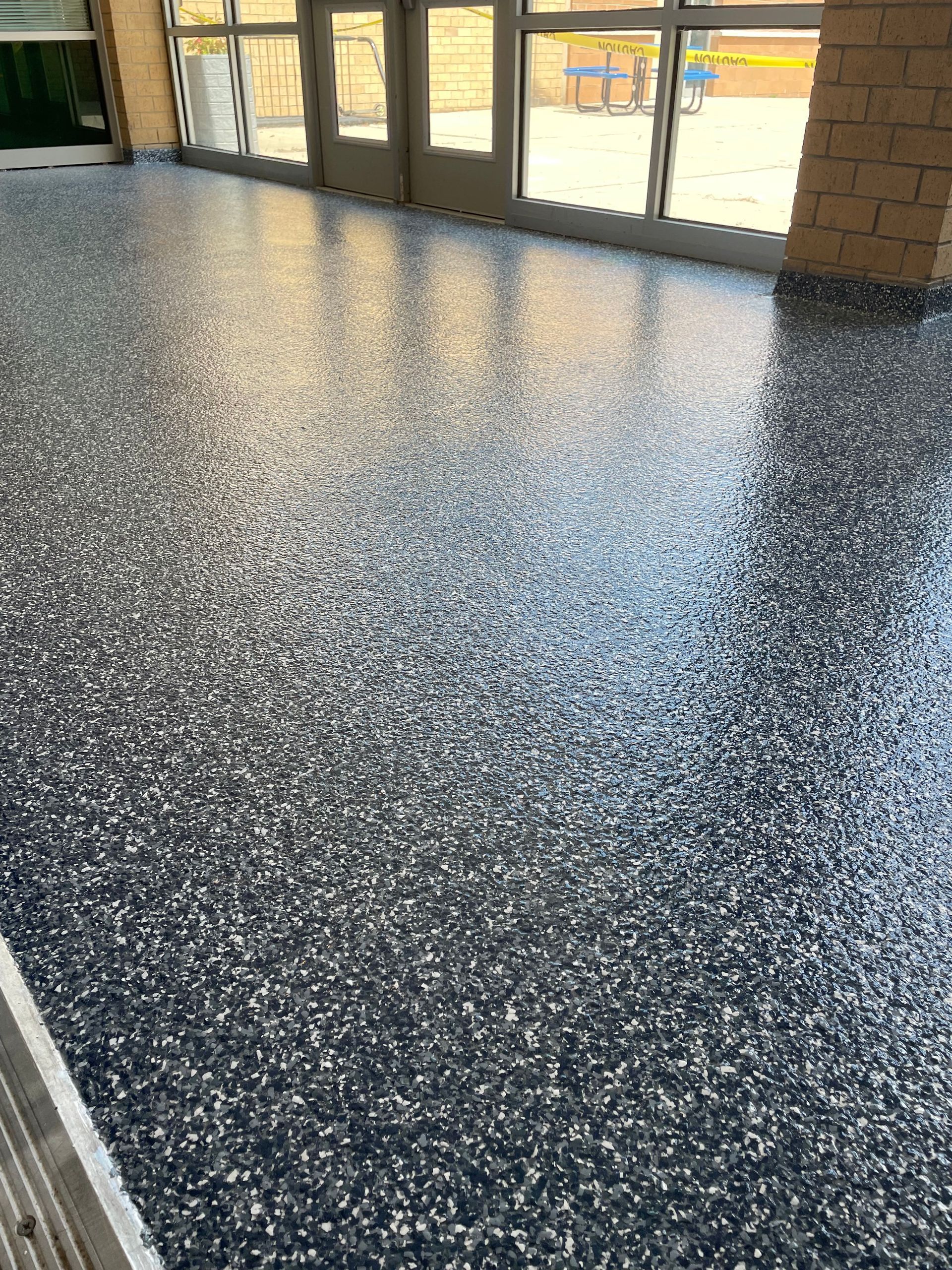 A large room with a shiny floor in front of a door.