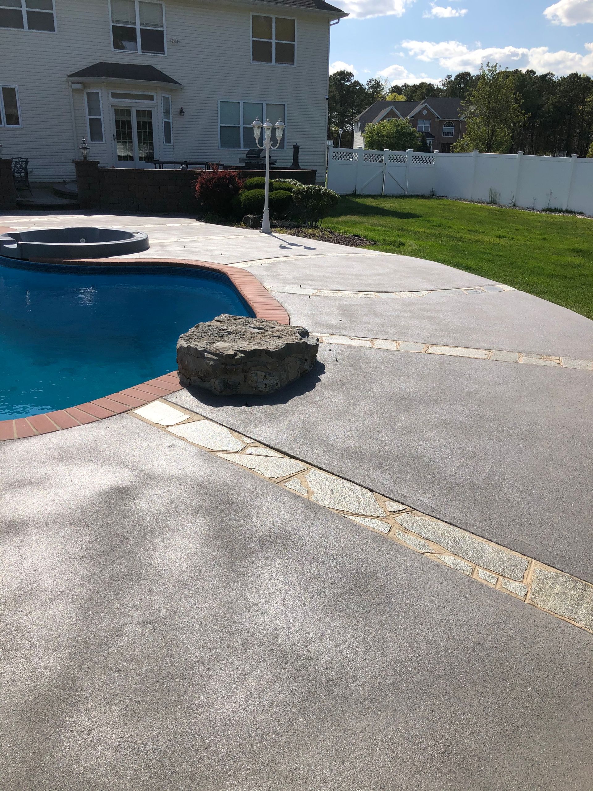 There is a large swimming pool in the backyard of a house.