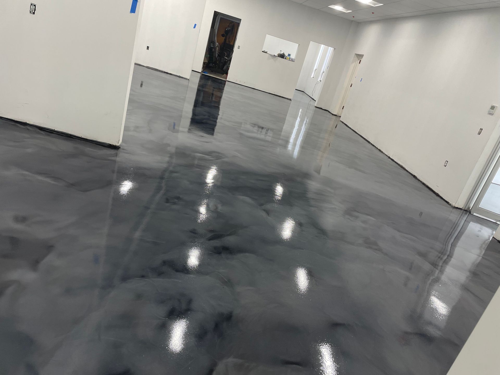 A large room with a shiny metallic floor and white walls.