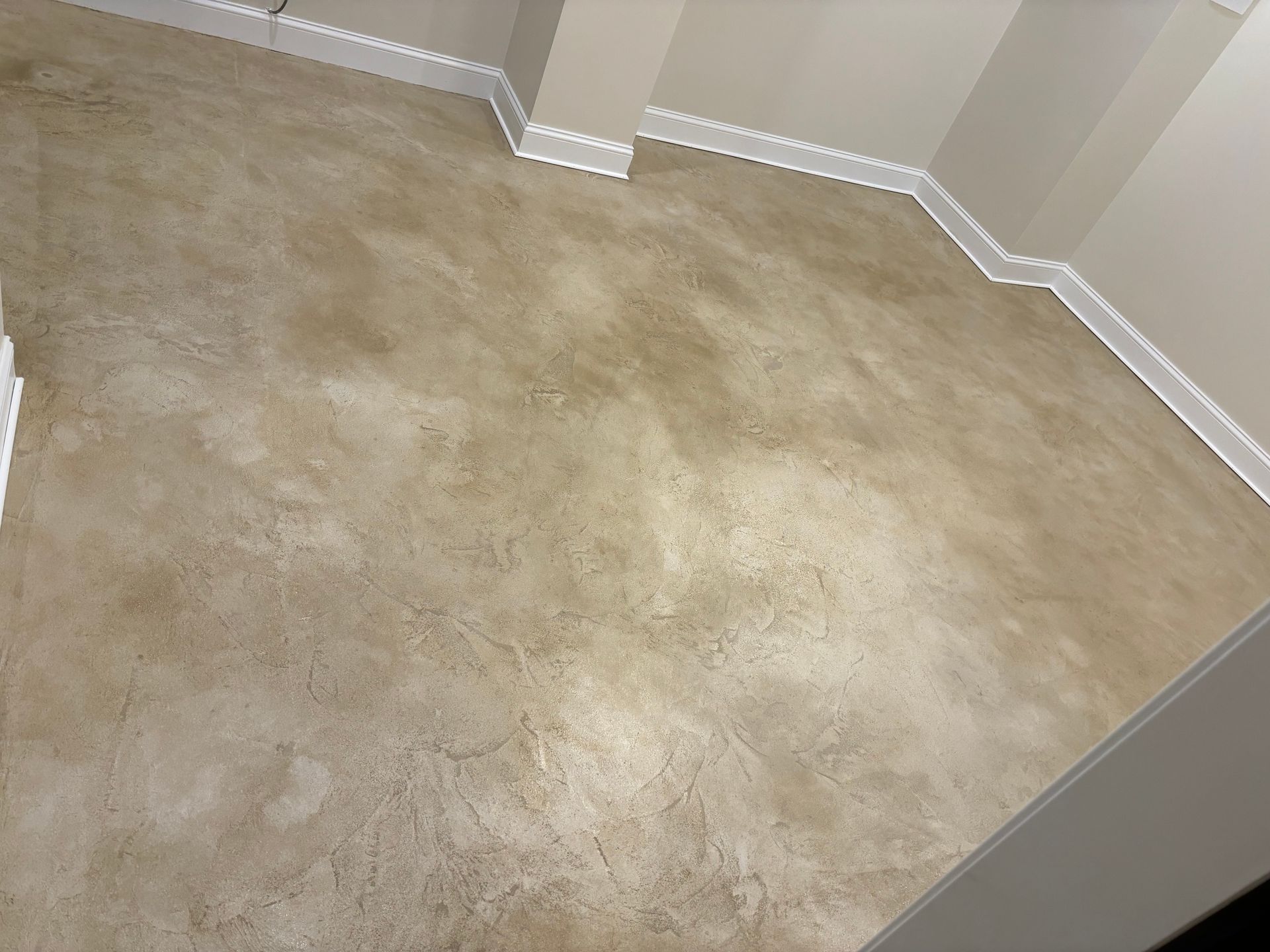 A room with a concrete floor and white trim.