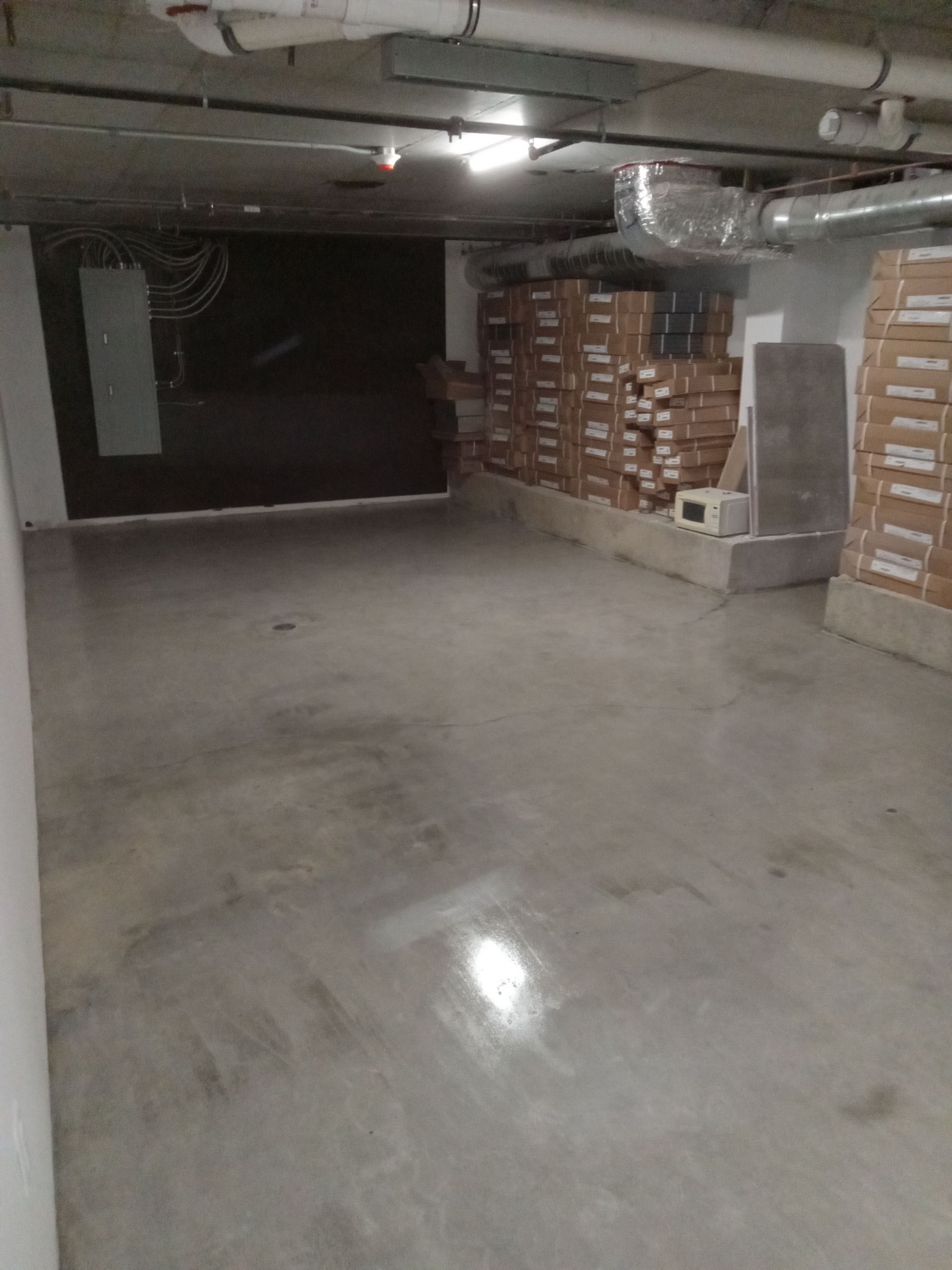 An empty basement with a lot of boxes on the floor.