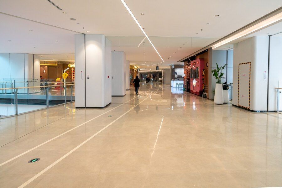 A person is walking down a long hallway in a mall.