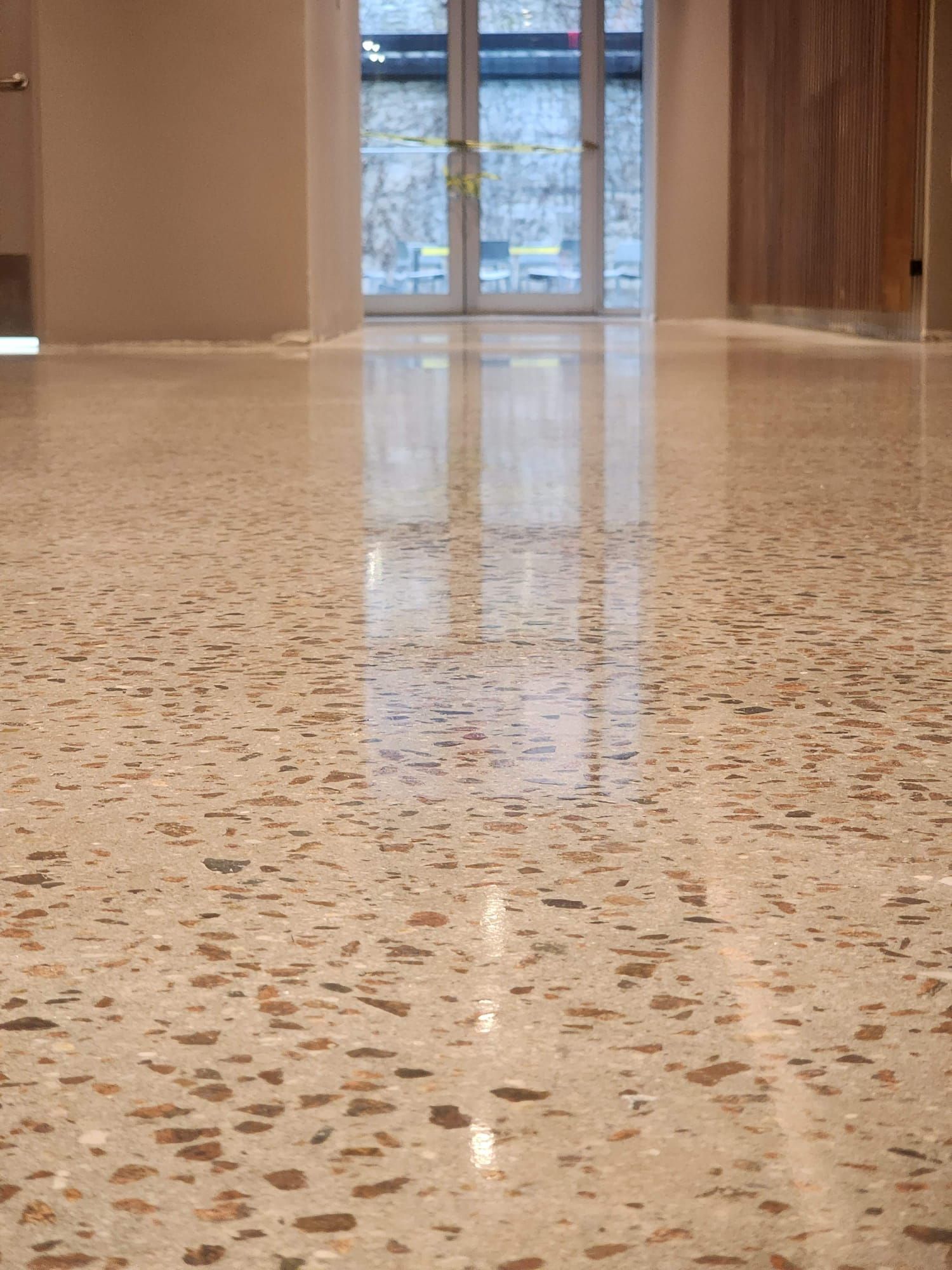 A close up of a shiny concrete floor with a window in the background.