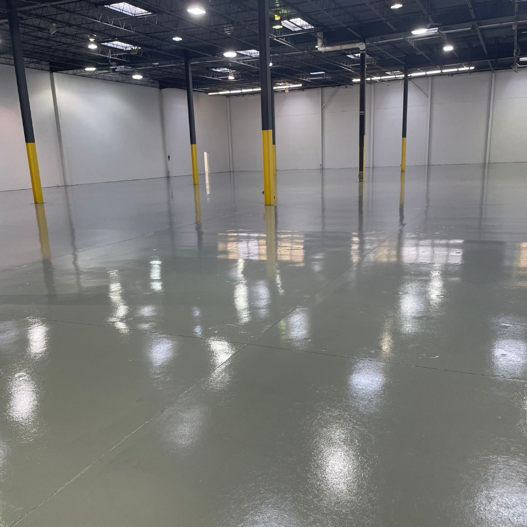 A large empty warehouse with a shiny floor and white walls.