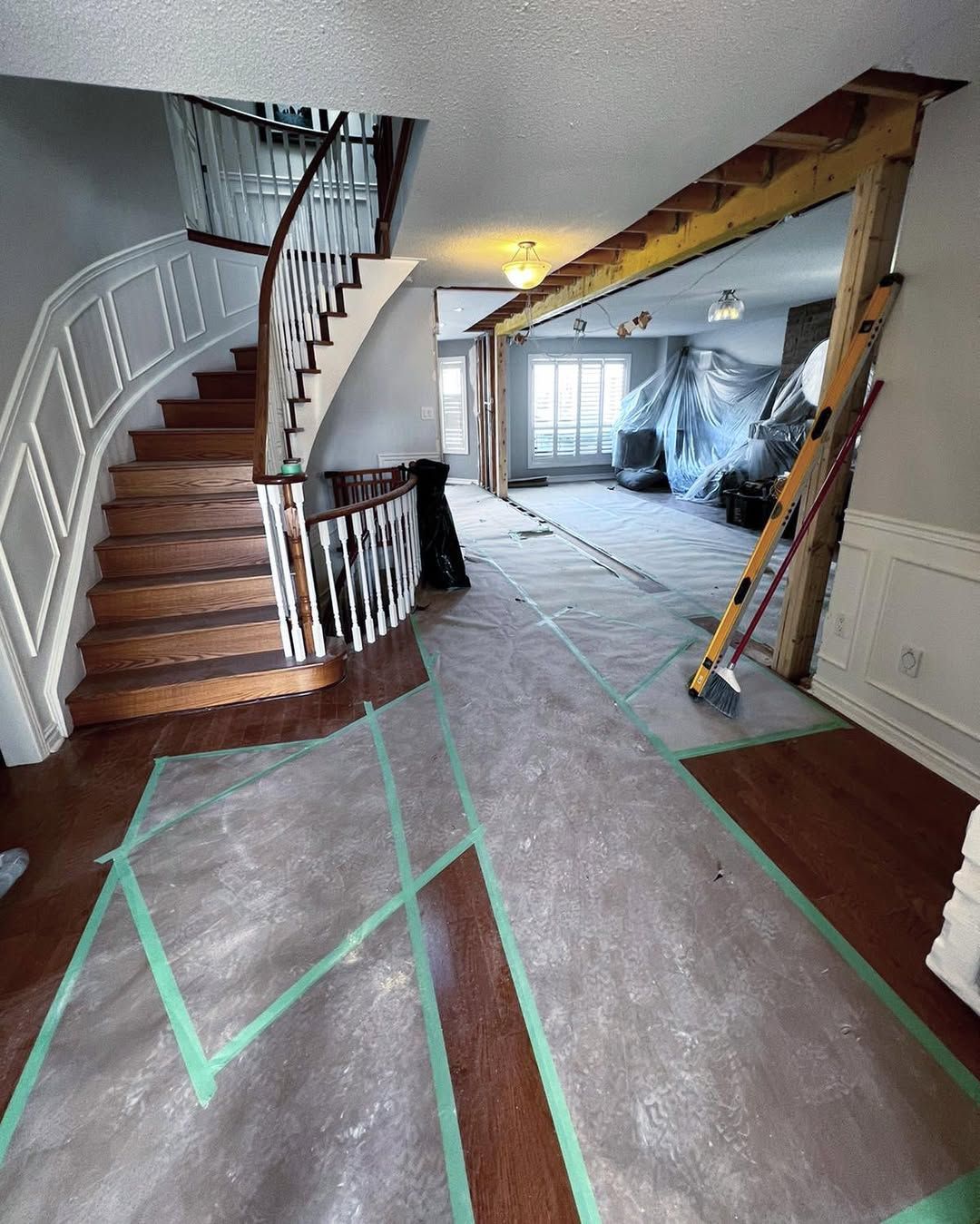 Man in black shirt holding coffee mug, smiling in a kitchen.