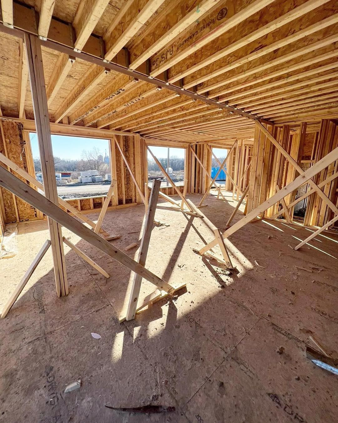 Man in black shirt holding coffee mug, smiling in a kitchen.