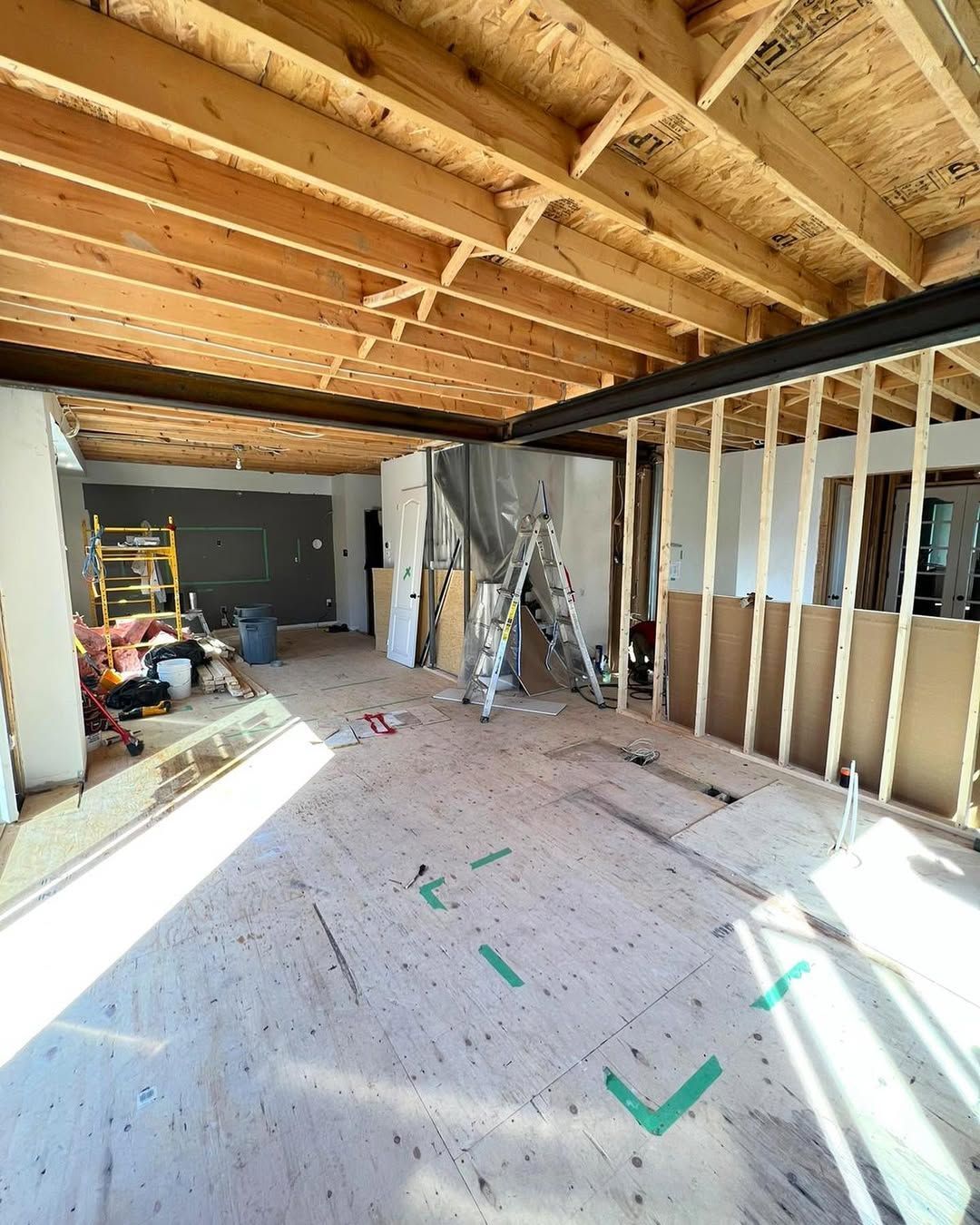 Man in black shirt holding coffee mug, smiling in a kitchen.