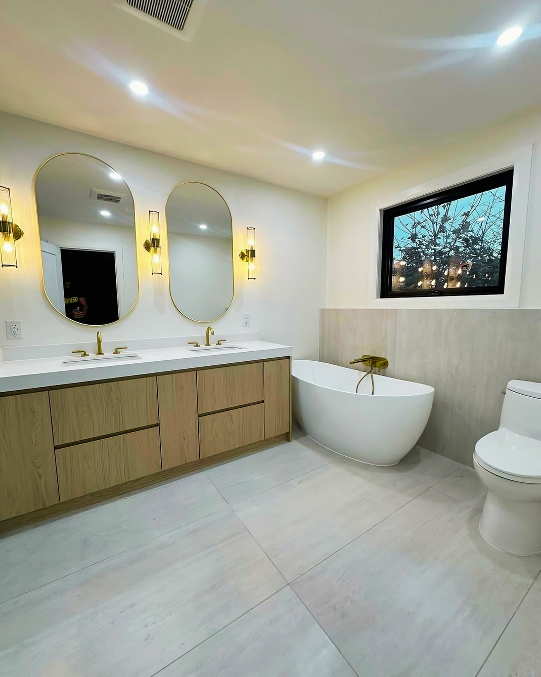 Man in black shirt holding coffee mug, smiling in a kitchen.