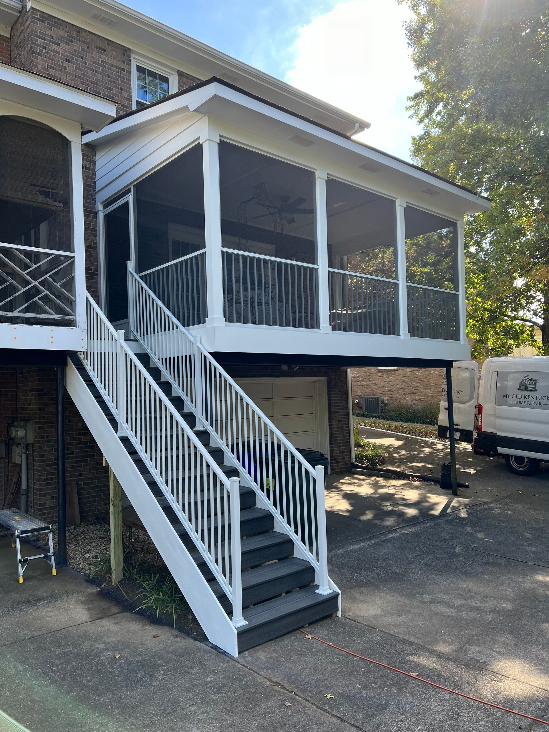 A house with a screened in porch and stairs.