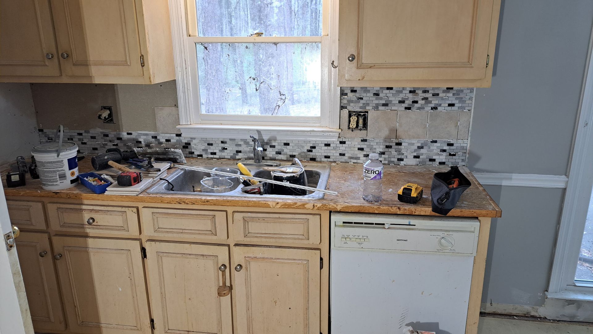 A kitchen with a sink , dishwasher , and window.