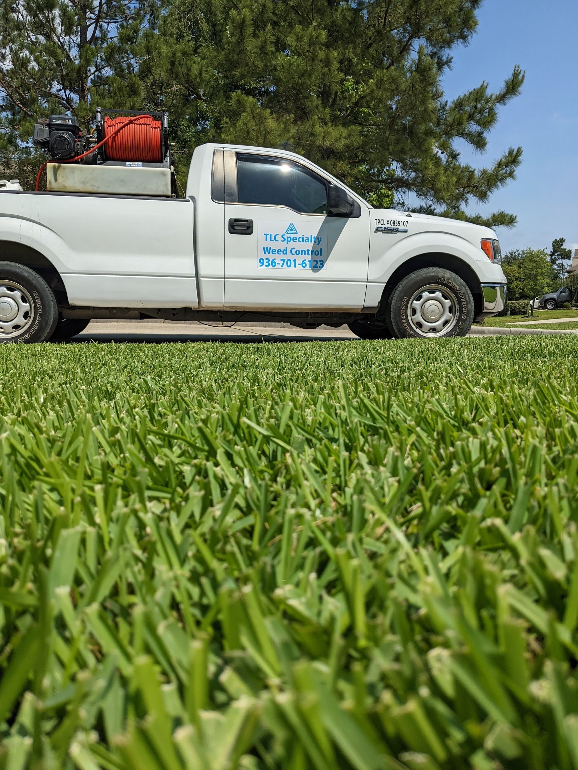 A white truck is parked in a grassy field.