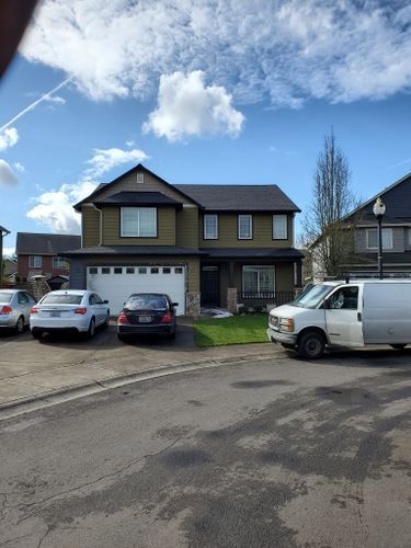 A white van is parked in front of a house