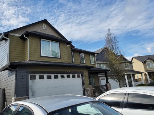 A house with a garage and a car parked in front of it.