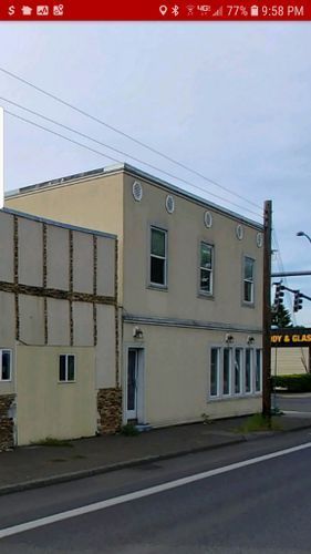 A picture of a building on the side of the road taken on a cell phone.