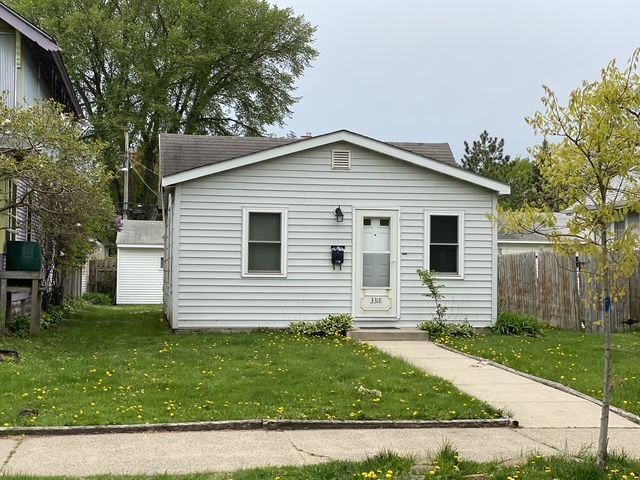 Gray siding on a building's exterior corner, with visible wood grain and a vertical trim piece.