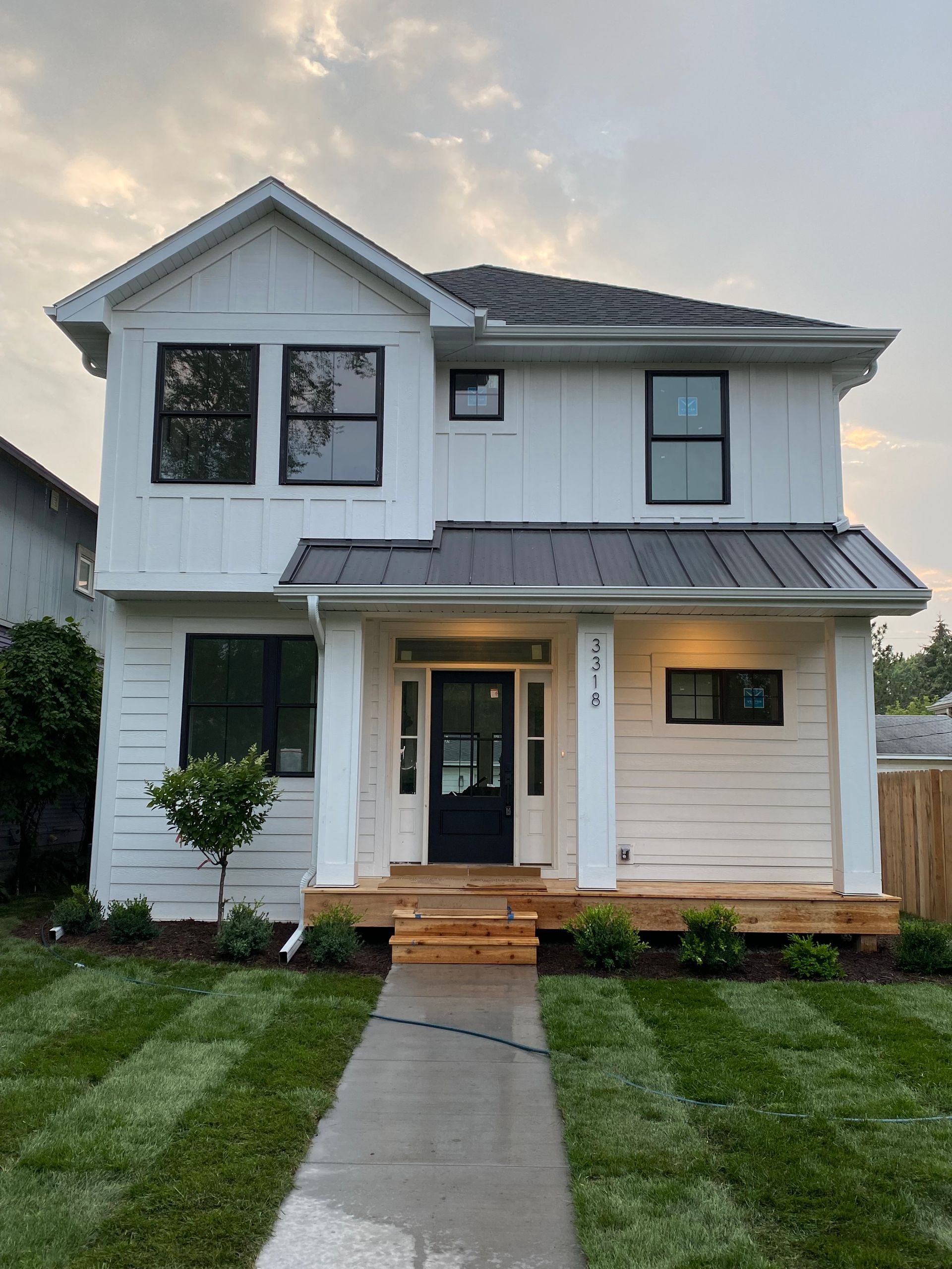 Roofer installing shingles on a slanted roof; close-up view of the shingle surface and worker in the background.