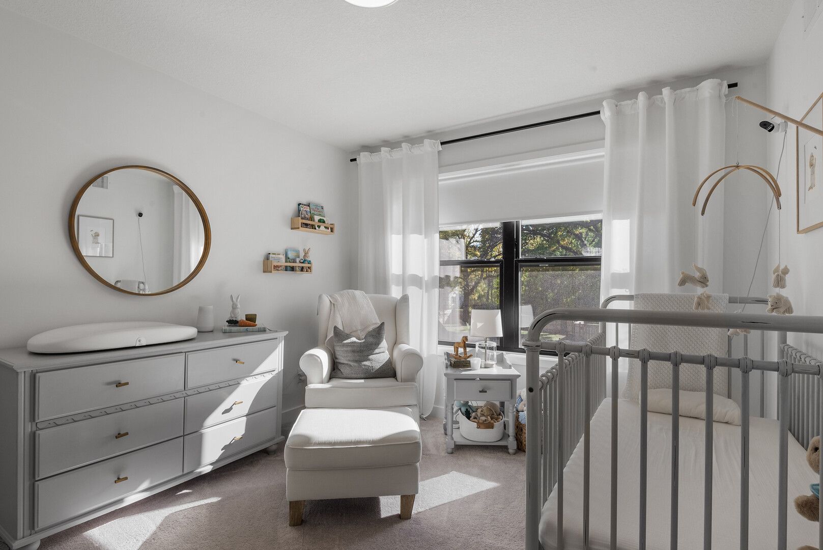 Bright sunroom with hardwood floor, window seat, and gray paneled walls.