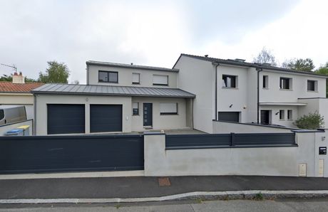 Une maison blanche avec un patio et des chaises devant