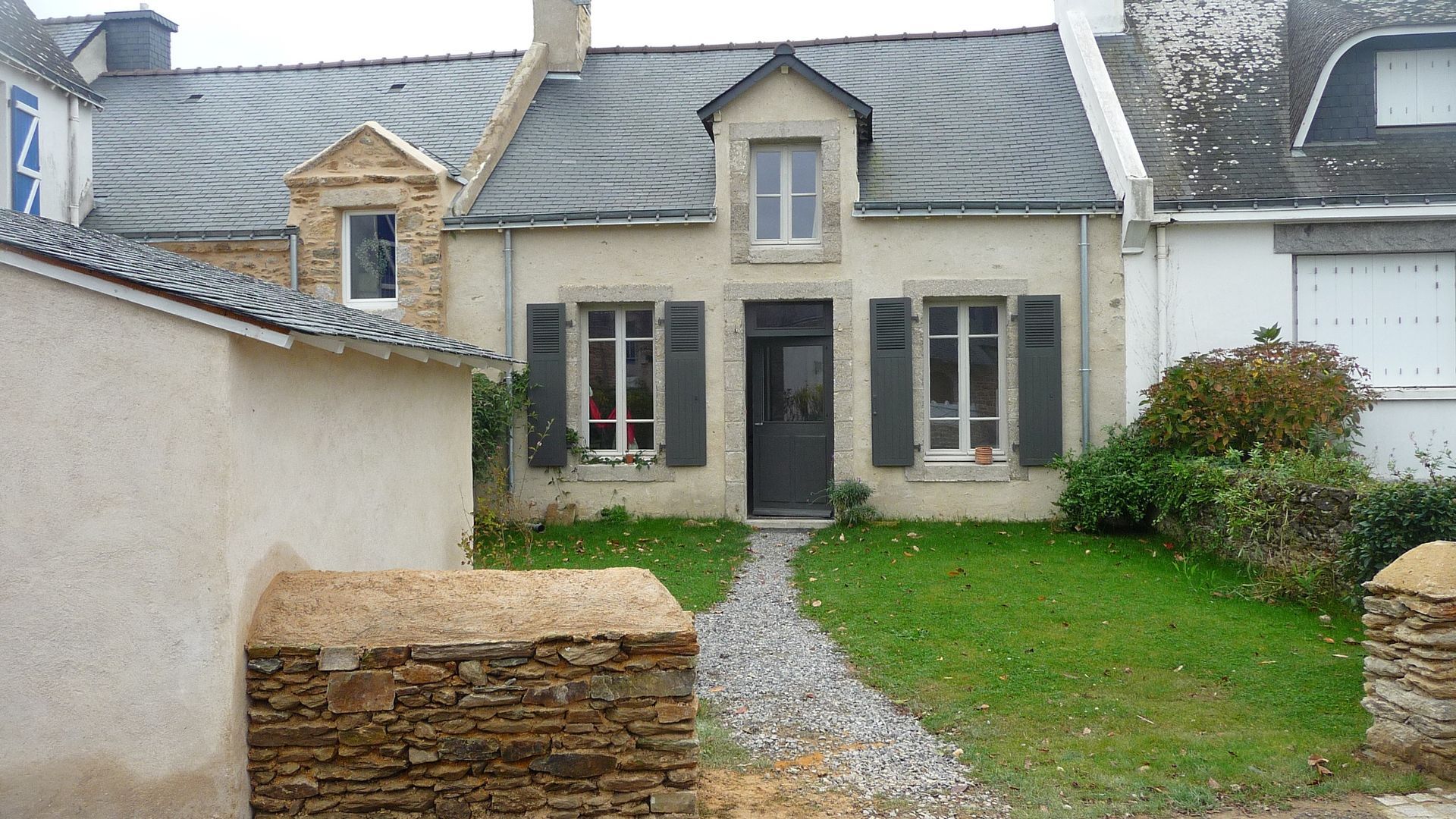 Une grande maison blanche avec des volets aux fenêtres
