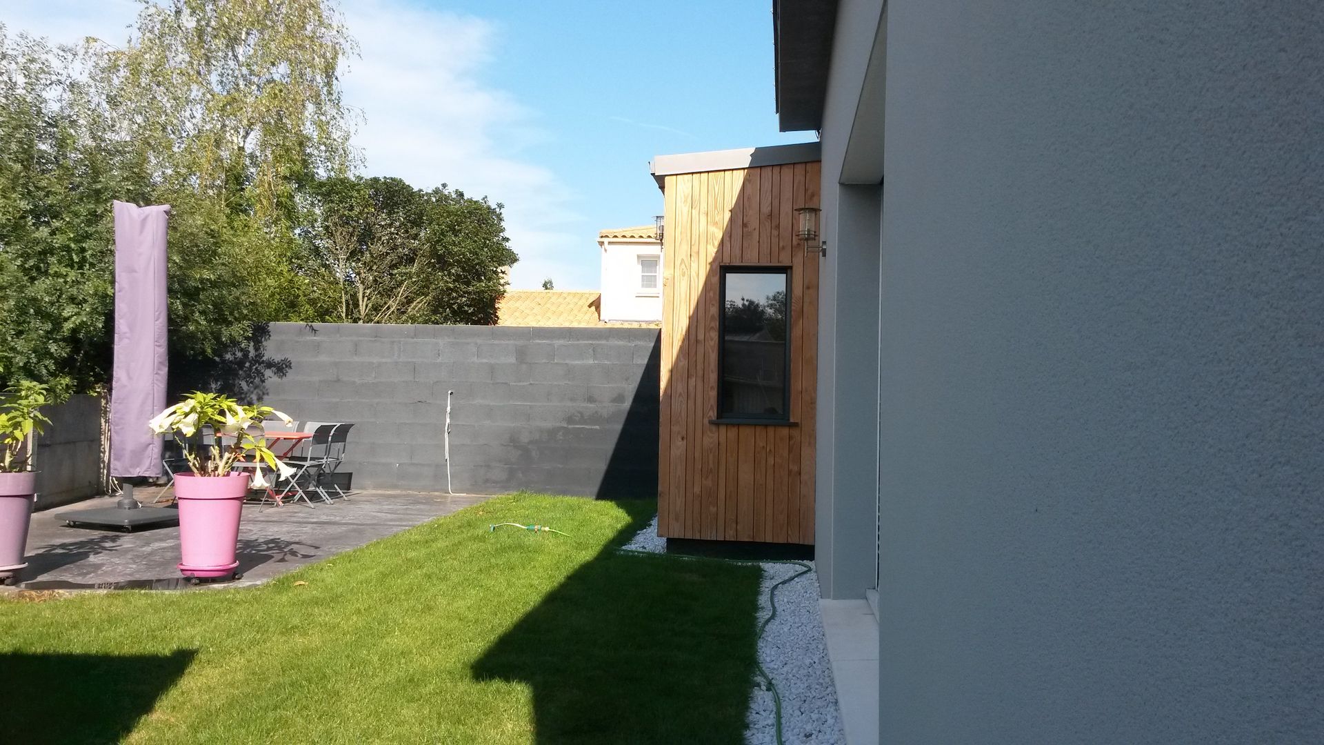 Une maison blanche avec un patio et des chaises devant