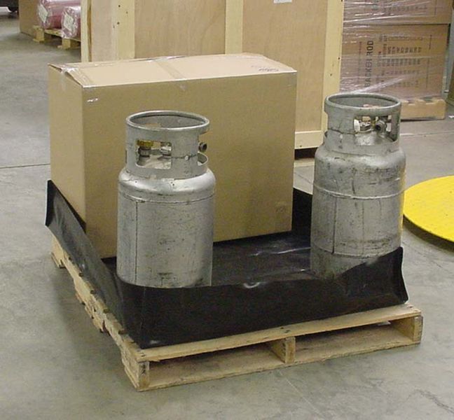 Two gas cylinders are sitting on a wooden pallet