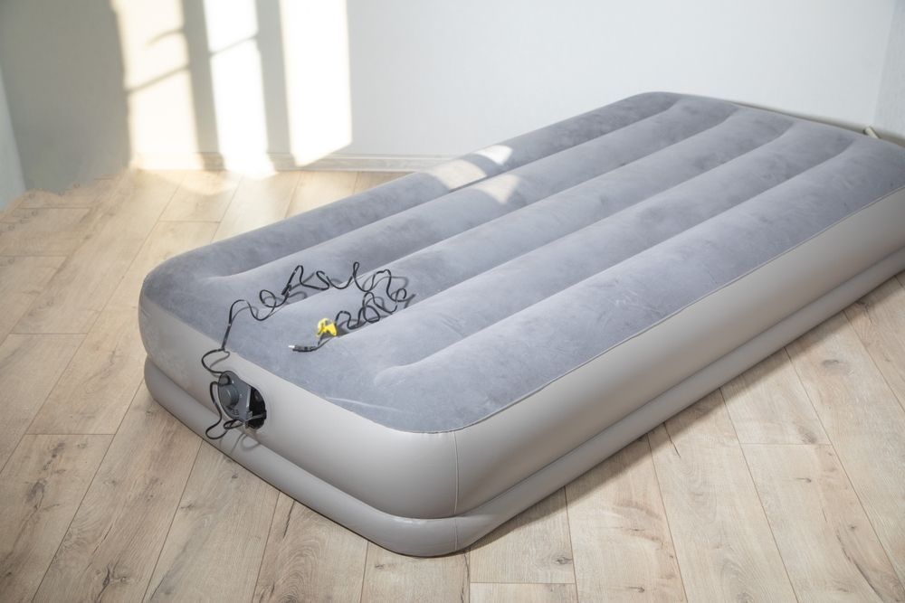 An air mattress is sitting on a wooden floor in a room.