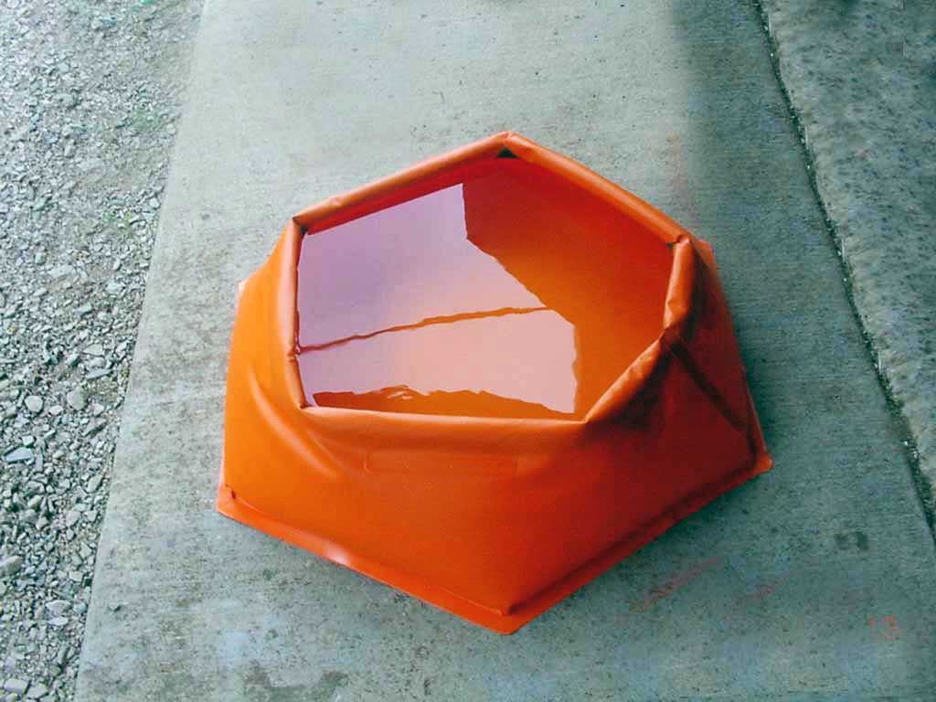 An orange container filled with water sits on a concrete surface