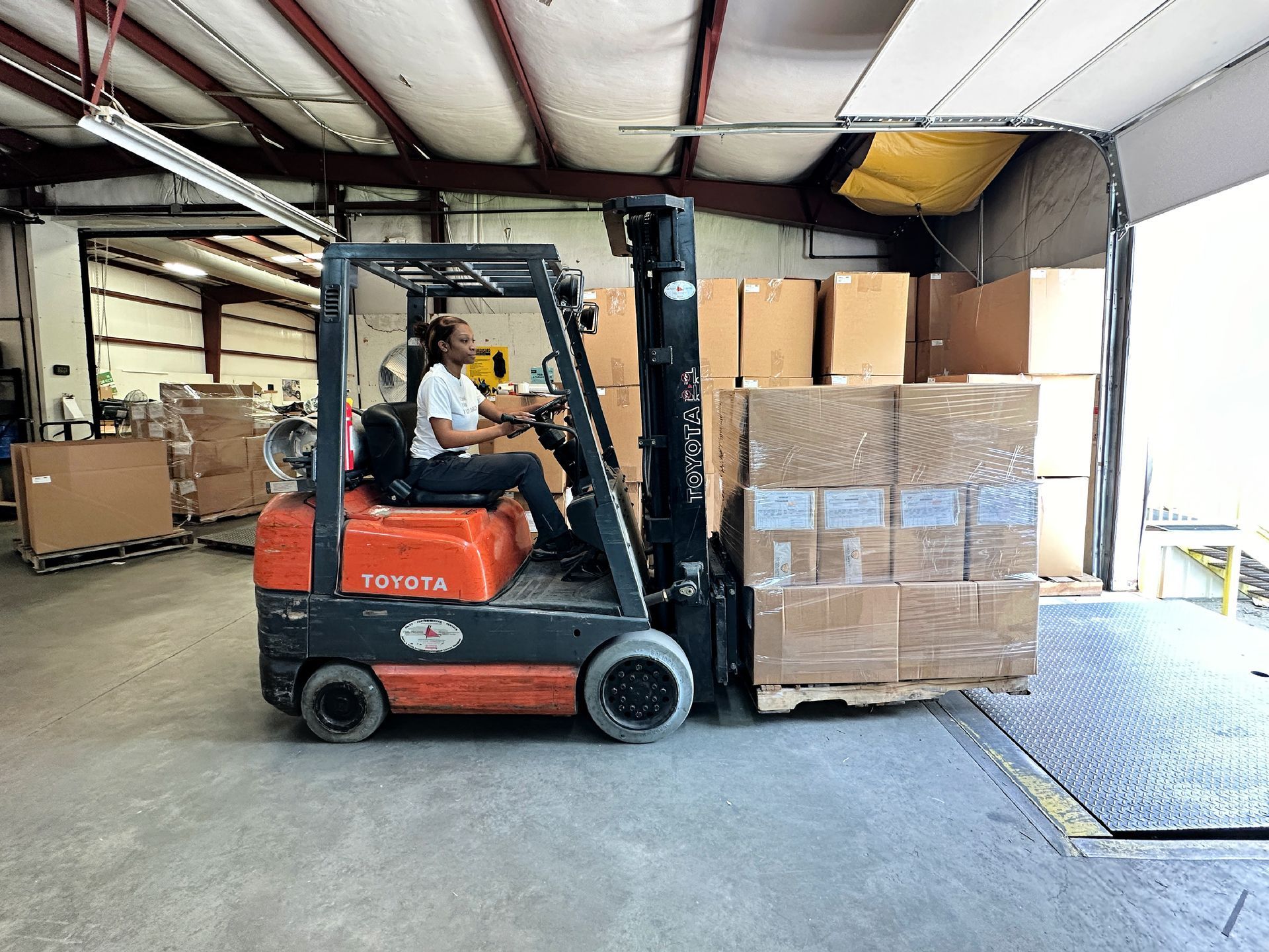 A forklift operator moving a pallet.