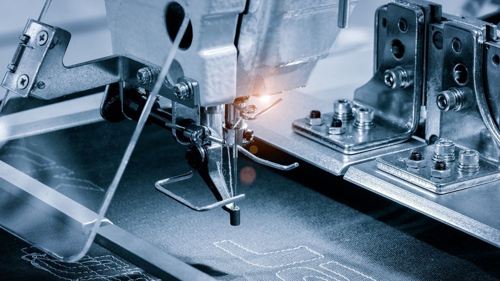 A sewing machine is working on a piece of fabric.