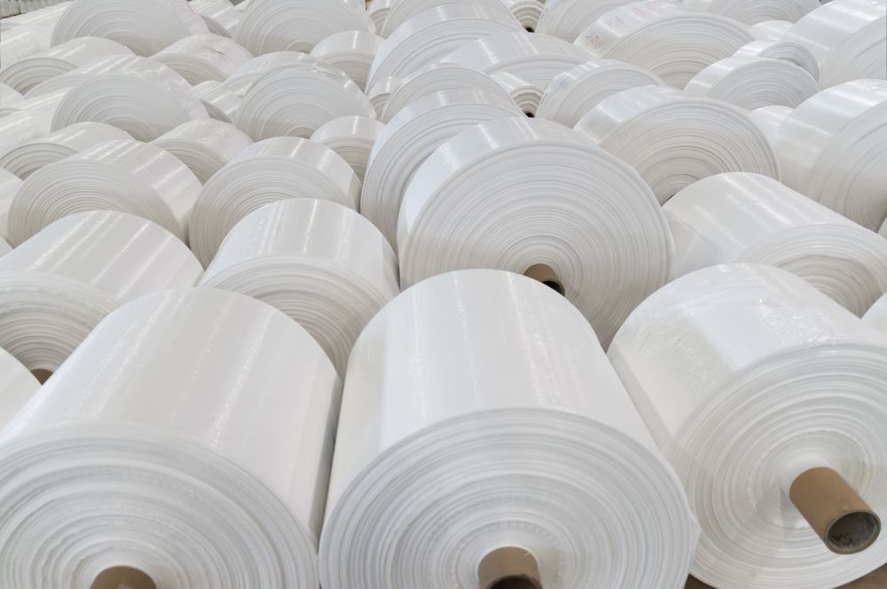 A bunch of white rolls of paper are stacked on top of each other.