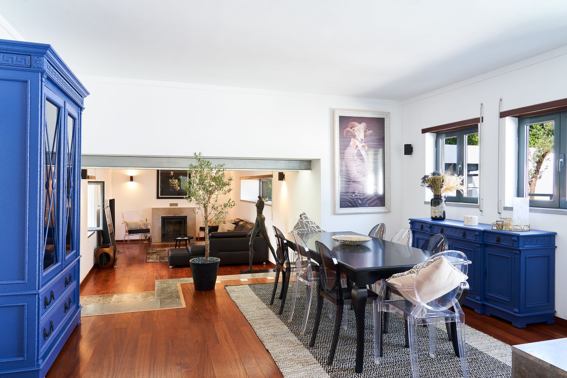 Living room with blue furniture, a fireplace, and a dining table.