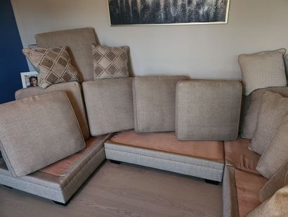 Modular beige and tan sectional sofa with patterned pillows in a living room