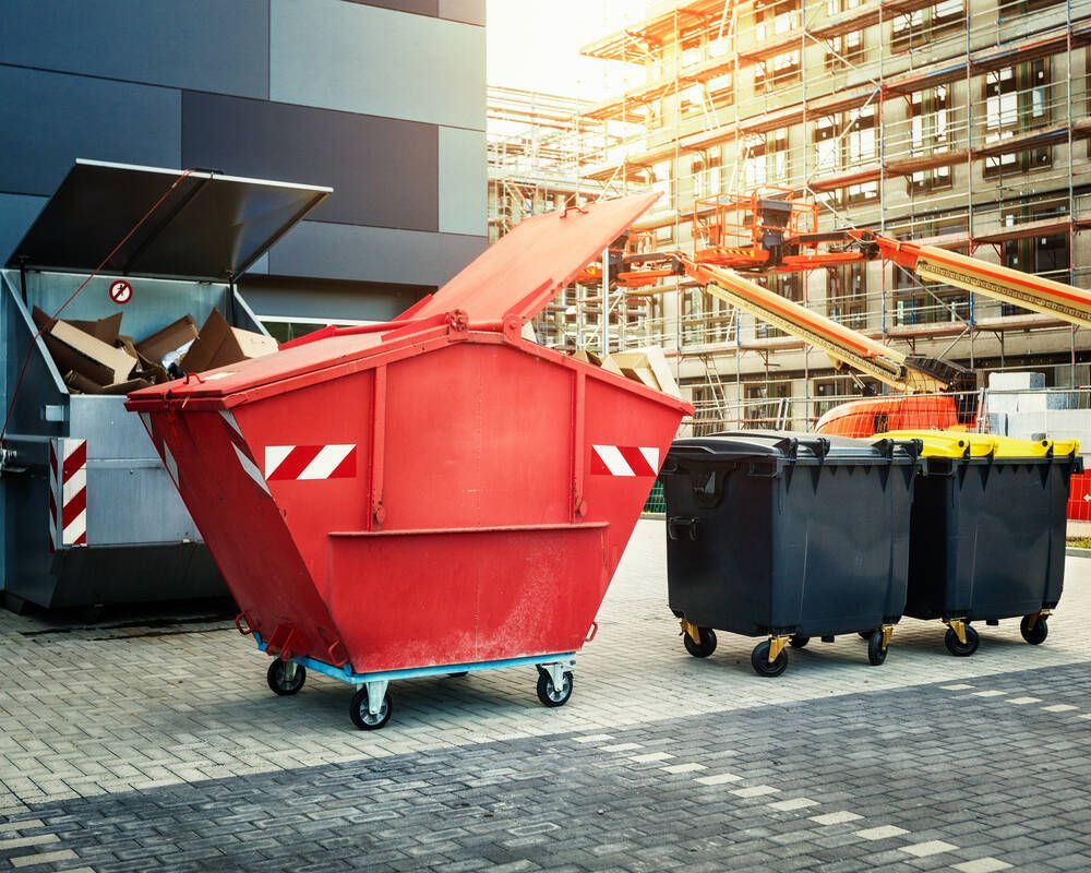 Red Dumpster and Two Black Dumpsters — Rob's Rubbish Removal in Murwillumbah, NSW