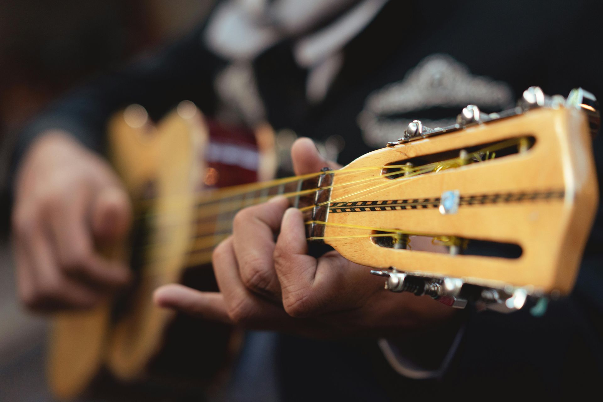 A close up of a person playing an acoustic guitar.