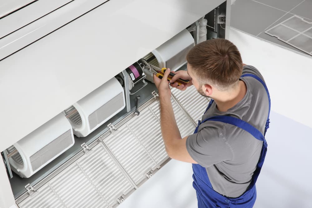 Male Technician Repairing Indoor Air Conditioner - Cooling System Experts In Berrimah, NT