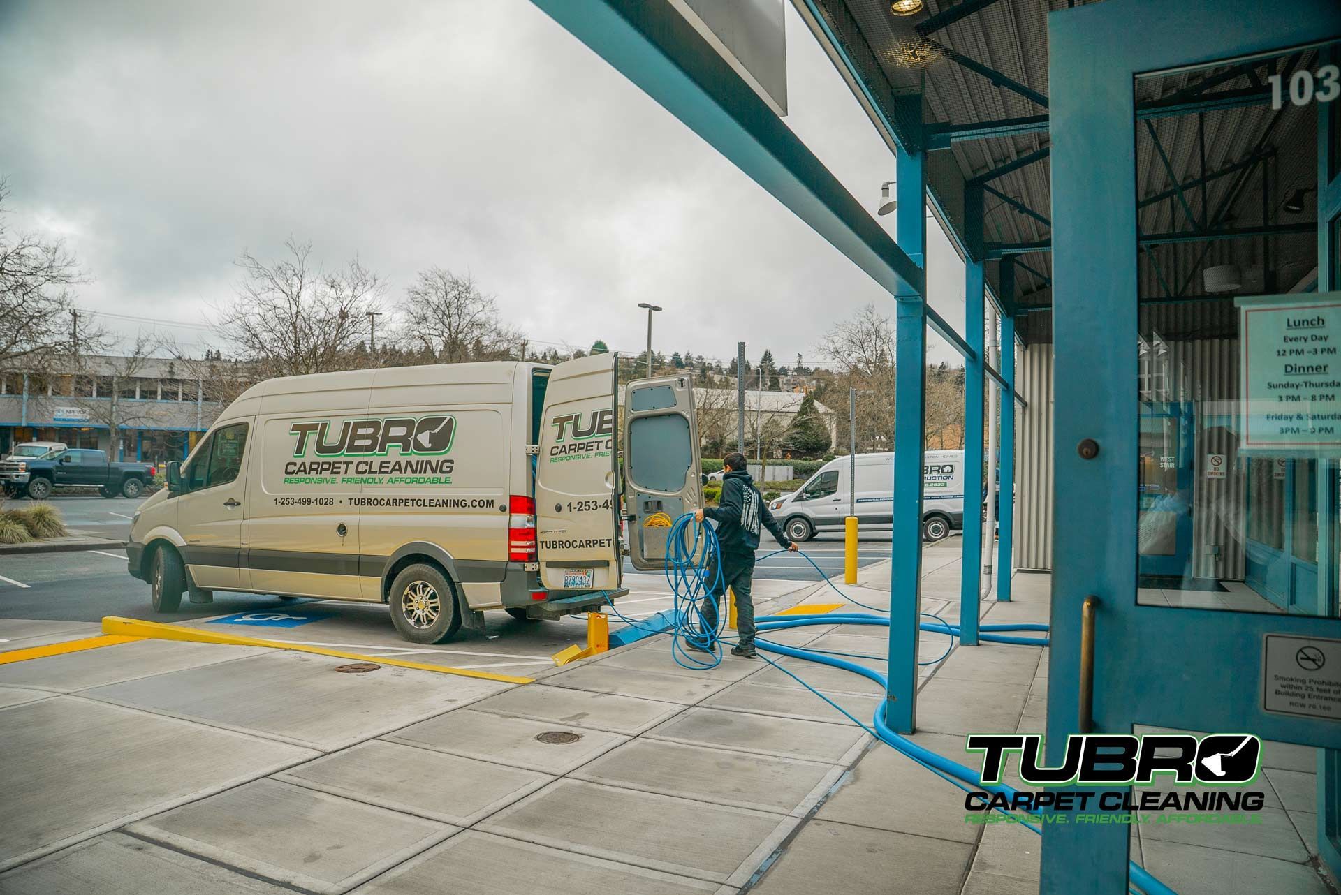 A carpet cleaning van is parked in front of a building.