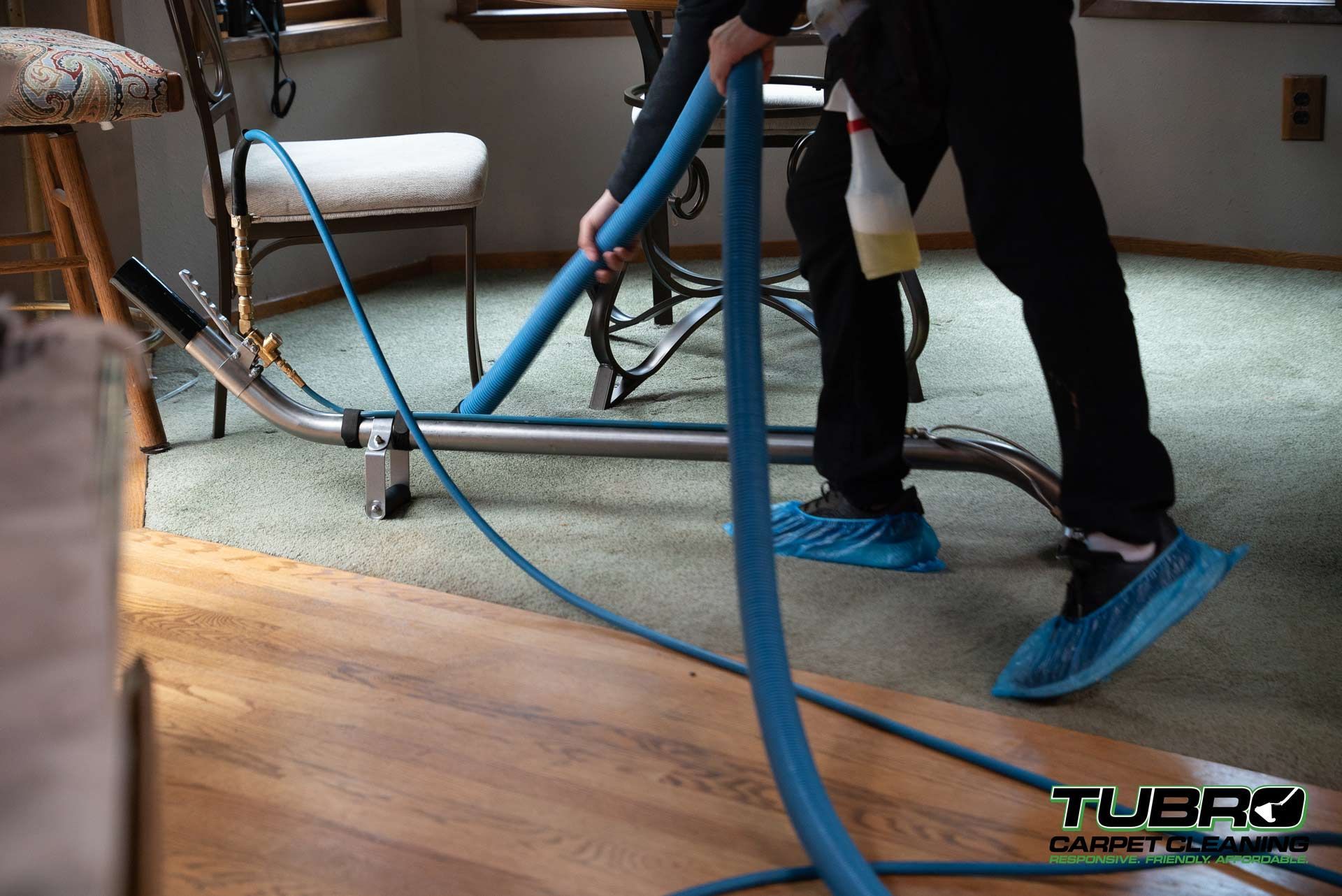 A person is using a vacuum cleaner to clean a carpet in a living room.