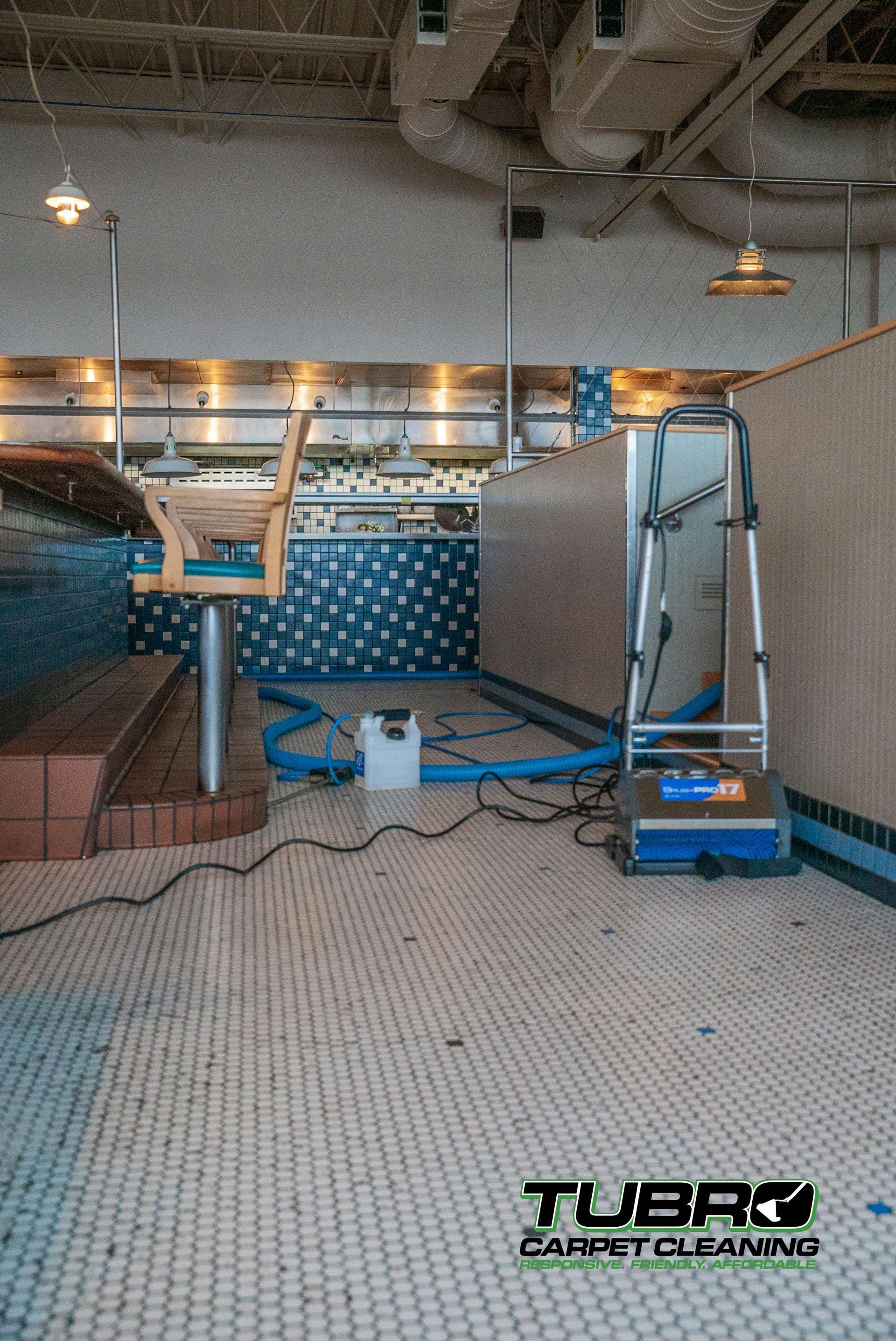 A vacuum cleaner is sitting on the floor of a restaurant.